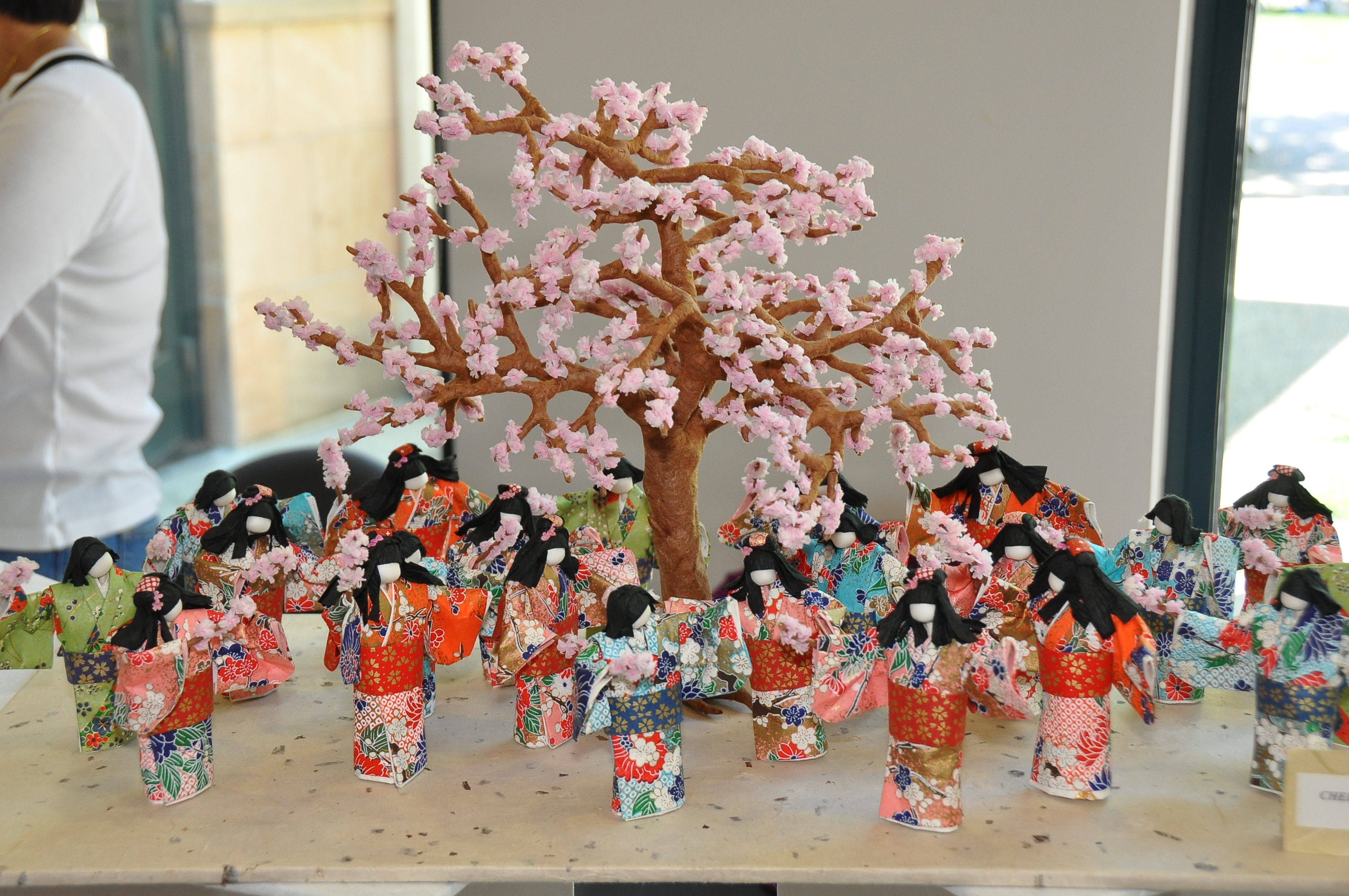 miniature dancing figures around a blossoming cherry tree